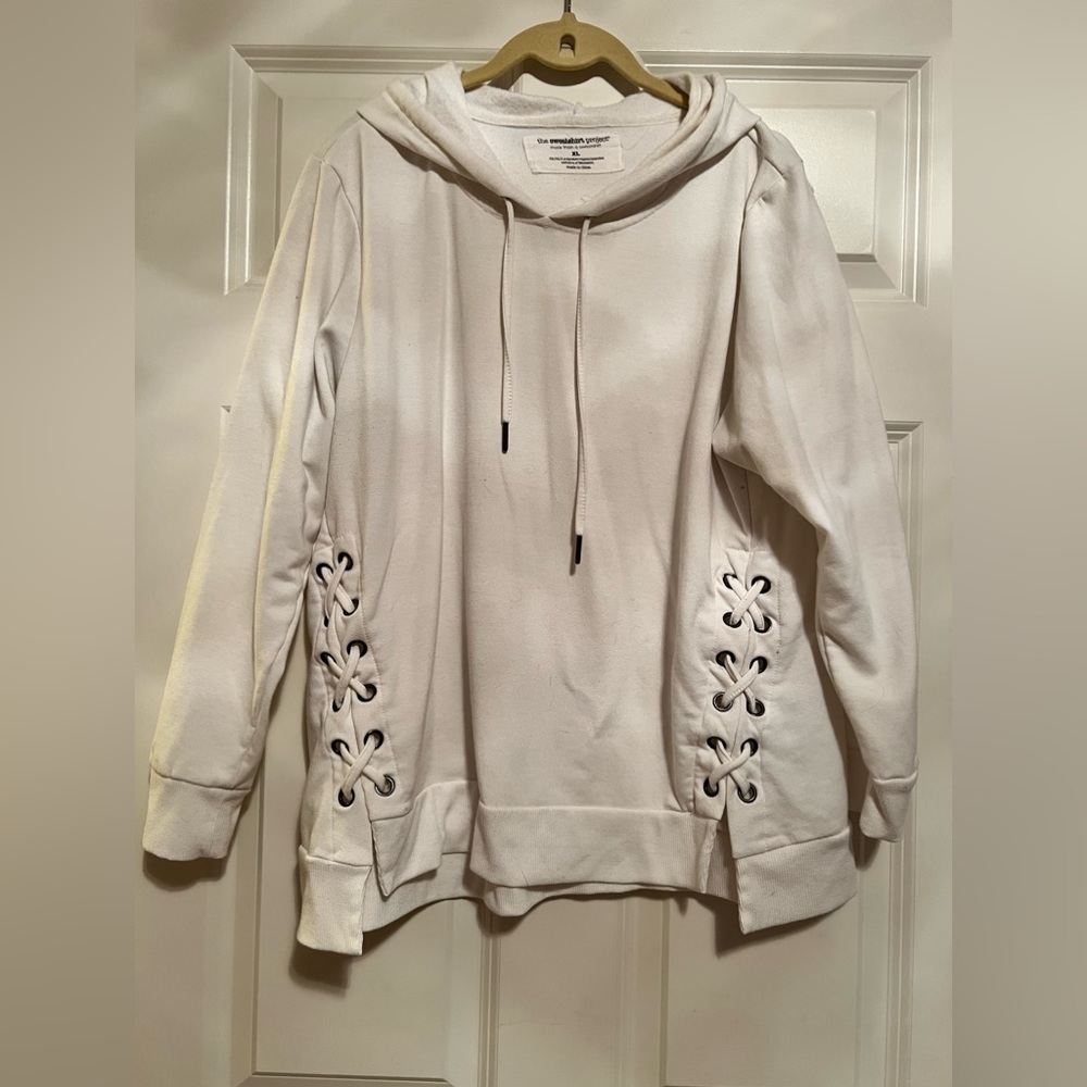 Cream sweatshirt with hood. Crossties on each side.